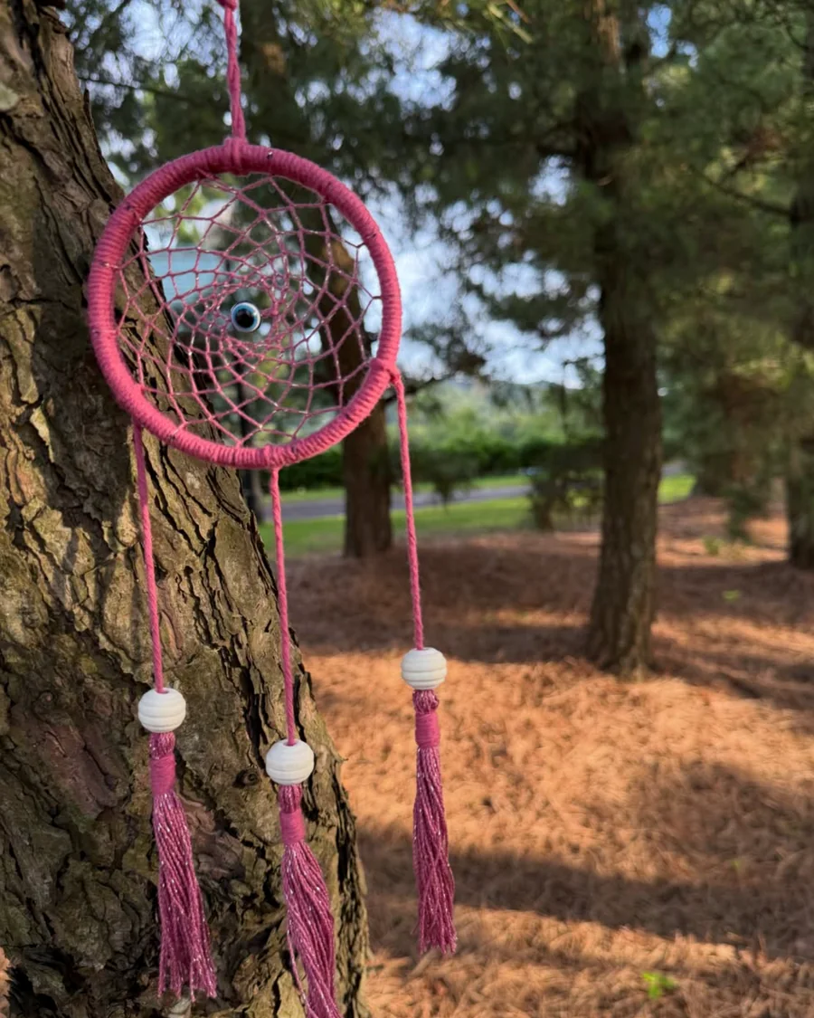 Filtro dos sonhos rosa em macramê fotografado na natureza