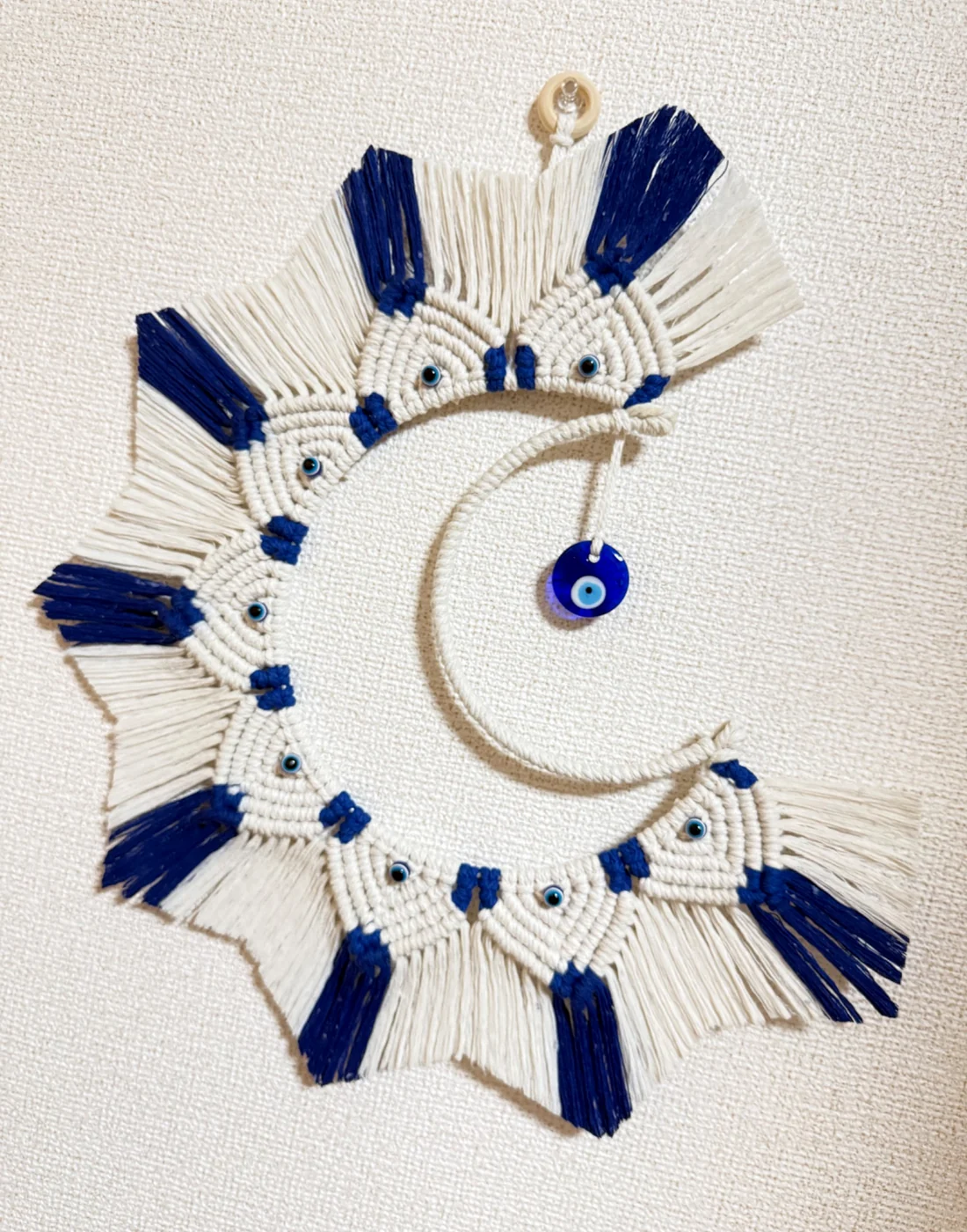 Lua em macramê branco e azul com olhos gregos
